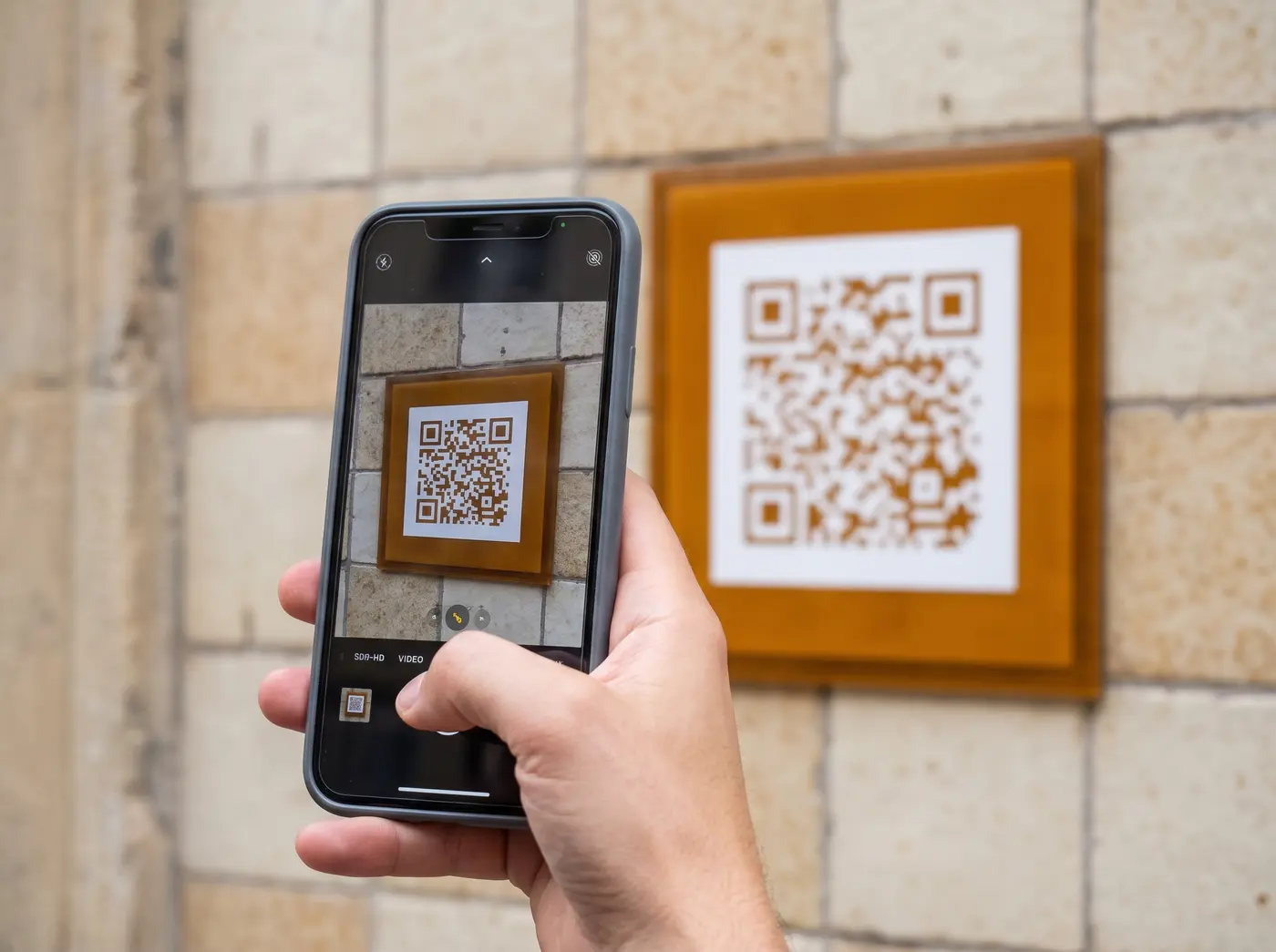Phone scanning a QR sighting sign on a wall