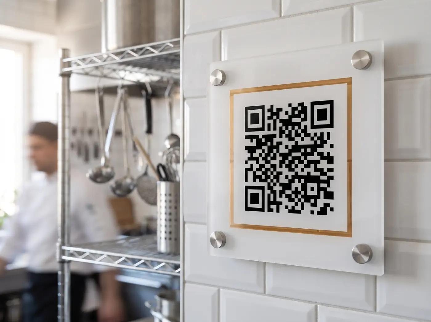 QR sighting sign mounted on white tiles in a commercial kitchen